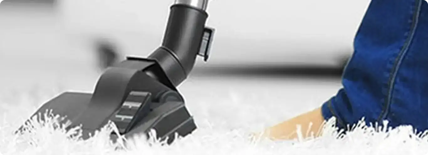 Close-up of a professional vacuuming a white carpet in Phoenix.